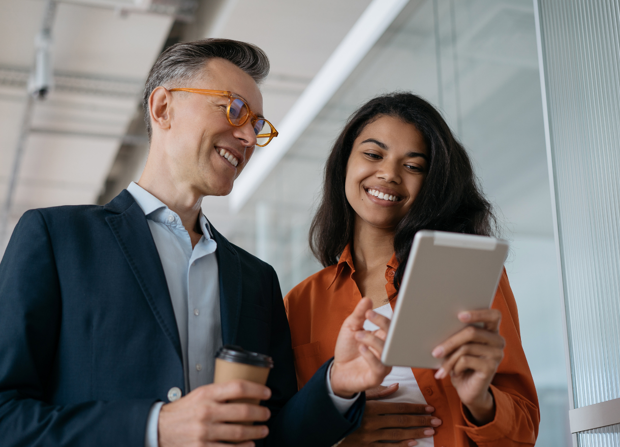Two colleagues reviewing AI capability progress on a tablet